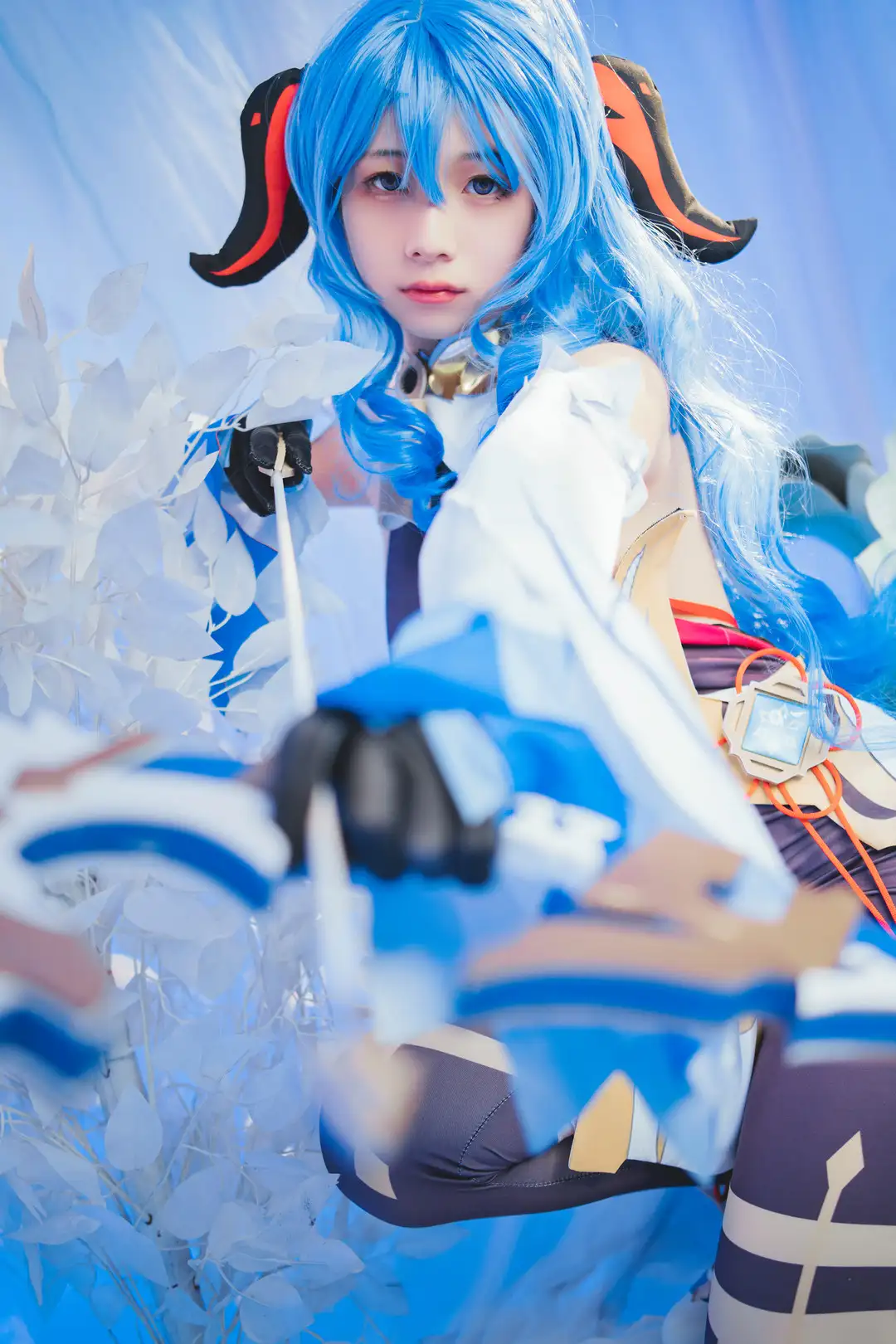 清青琴玖 原神甘雨cos 蓝色长发配黑红双角,白色披肩与金色铃铛领扣,手持长弓立于白色枝叶前 清青琴玖 原神甘雨cos 蓝色长发配黑红双角,白色披肩与金色铃铛领扣,手持长弓立于白色枝叶前