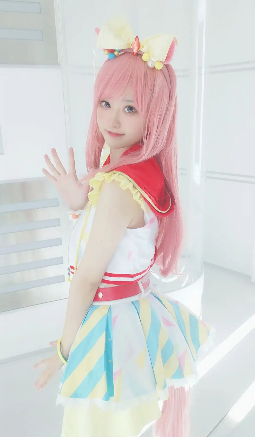 千阳(ちよ) 粉色长发马耳配黄色大蝴蝶结与红白水手领偶像服 蓝黄条纹裙,白色玻璃墙前回眸挥手 千阳(ちよ) 粉色长发马耳配黄色大蝴蝶结与红白水手领偶像服 蓝黄条纹裙,白色玻璃墙前回眸挥手